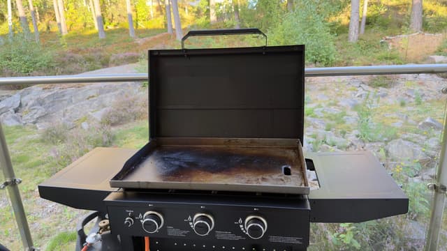 Hällmark stekbord med tre brännare med öppet lock och inbränd stekyta på en altan