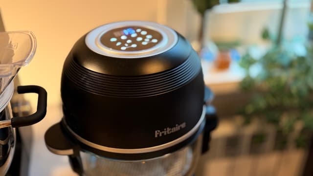 Fritaire airfryer i svart på köksbänken med upplyst kontrollpanel på locket