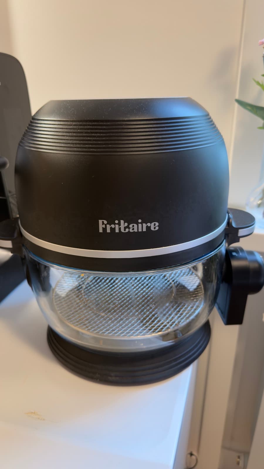 Fritaire airfryer framifrån med genomskinlig glasskål och luftställ i botten
