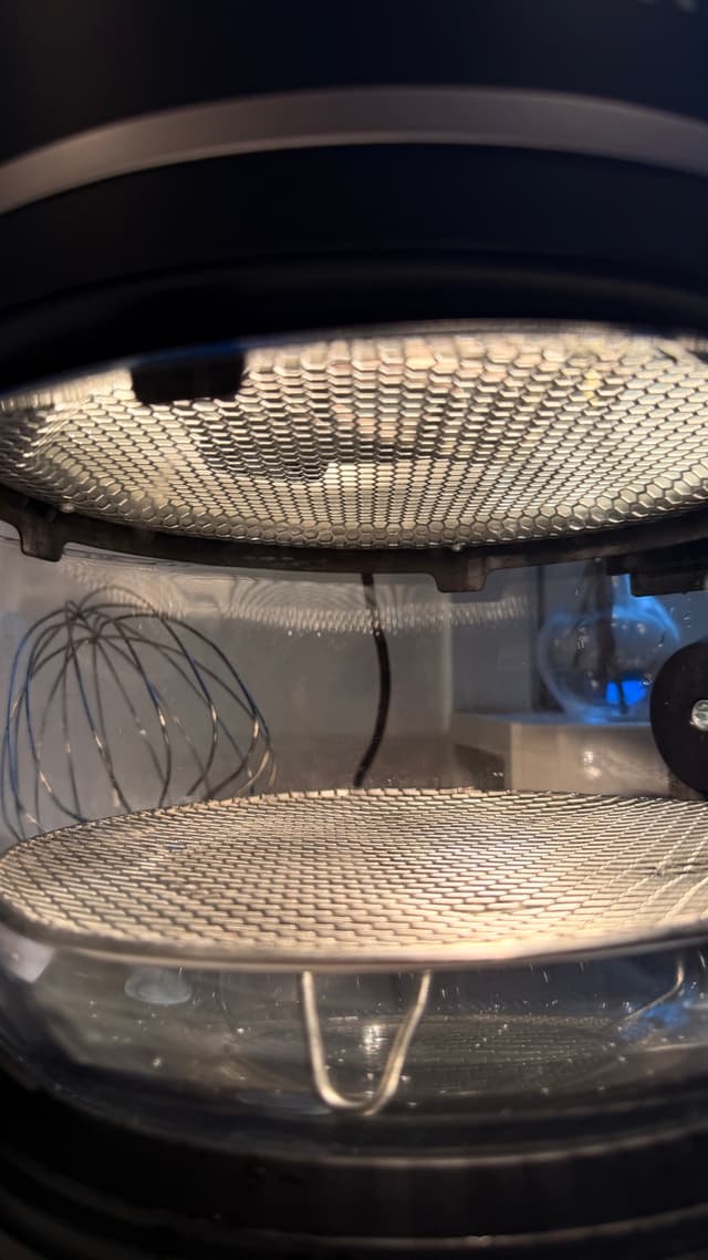 Insidan av Fritaire airfryers glasskål med luftställ och den roterande korgens ram