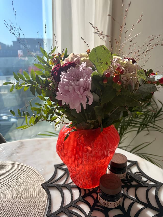 Euroflorists bukett Höstens juvel i röd vas på bordet